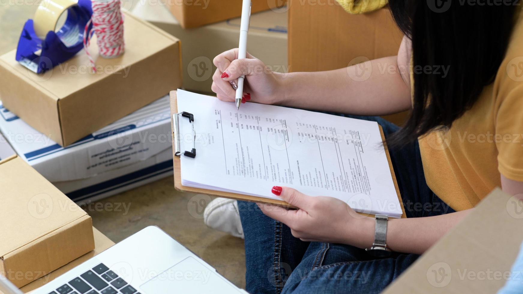 Woman checks stock files for shipping to customers. photo