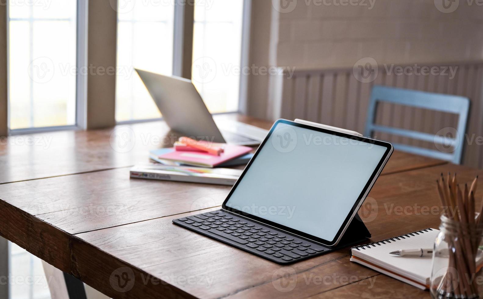 Tablet blank screen and office equipment on wooden table. photo