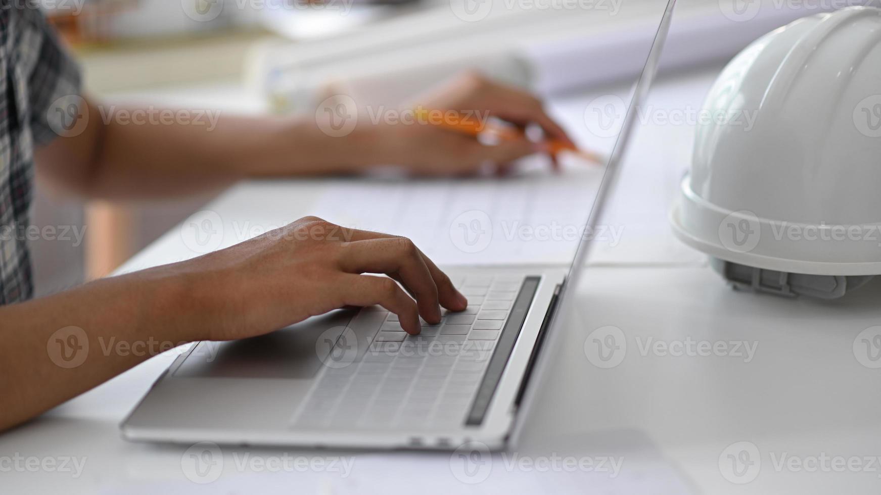 Young man hand is using a laptop keyboard. photo