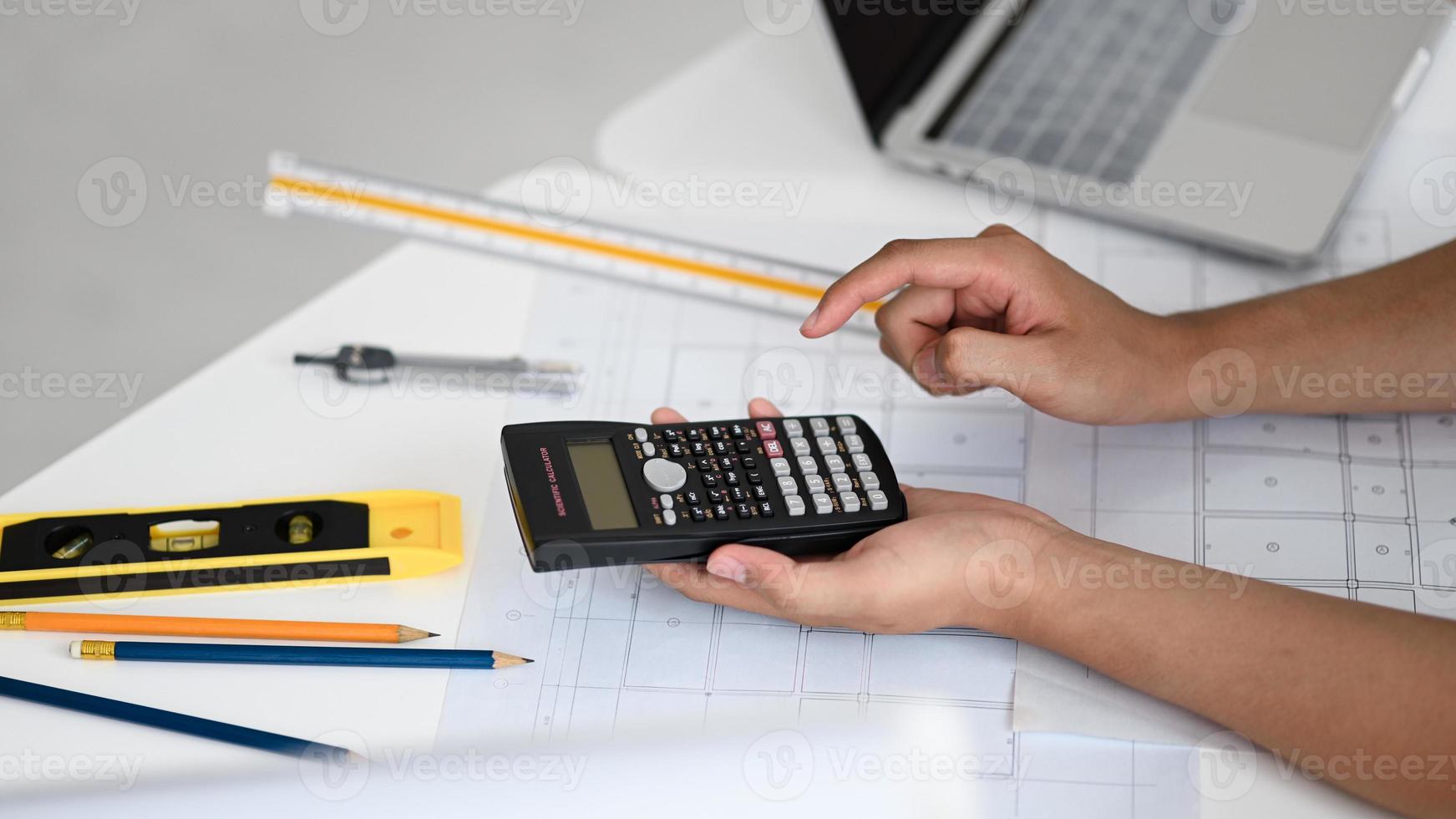 Engineers use a calculator to calculate house plans. photo