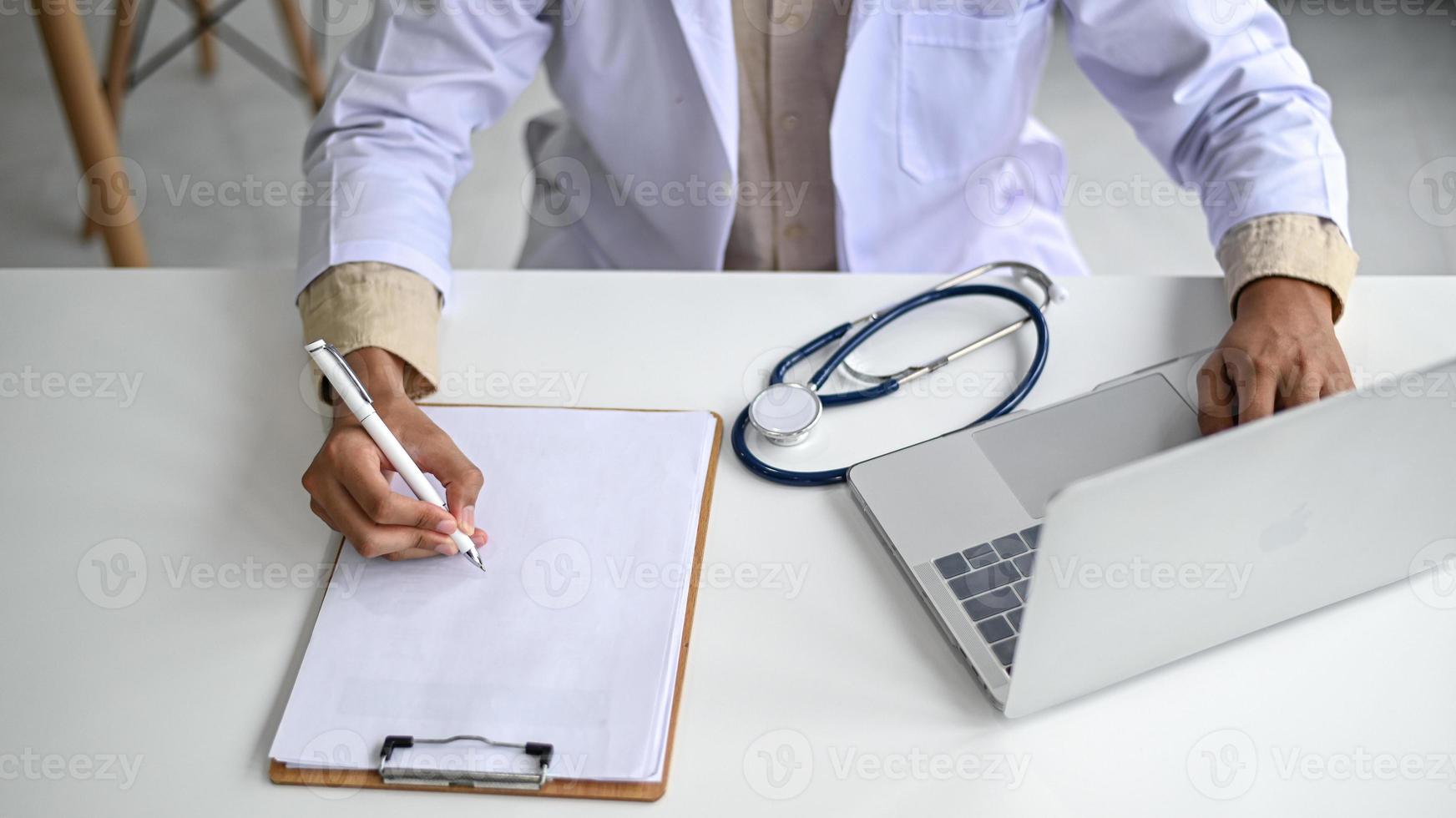 A medical professional in a lab coat holds a pencil on an empty file. photo