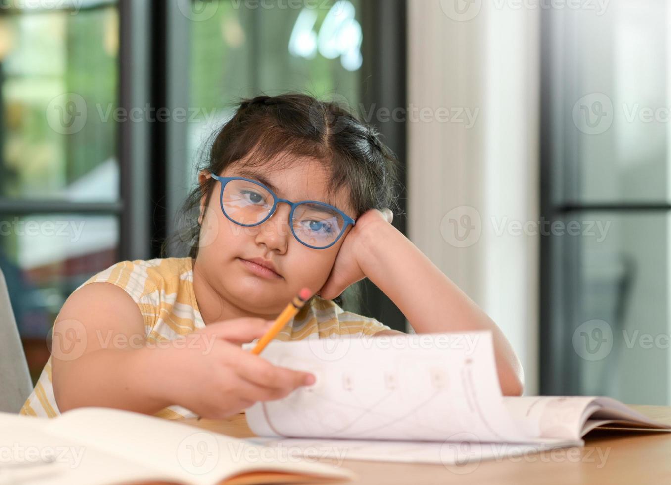 The child girl puts her hand on her head to look at the camera. photo