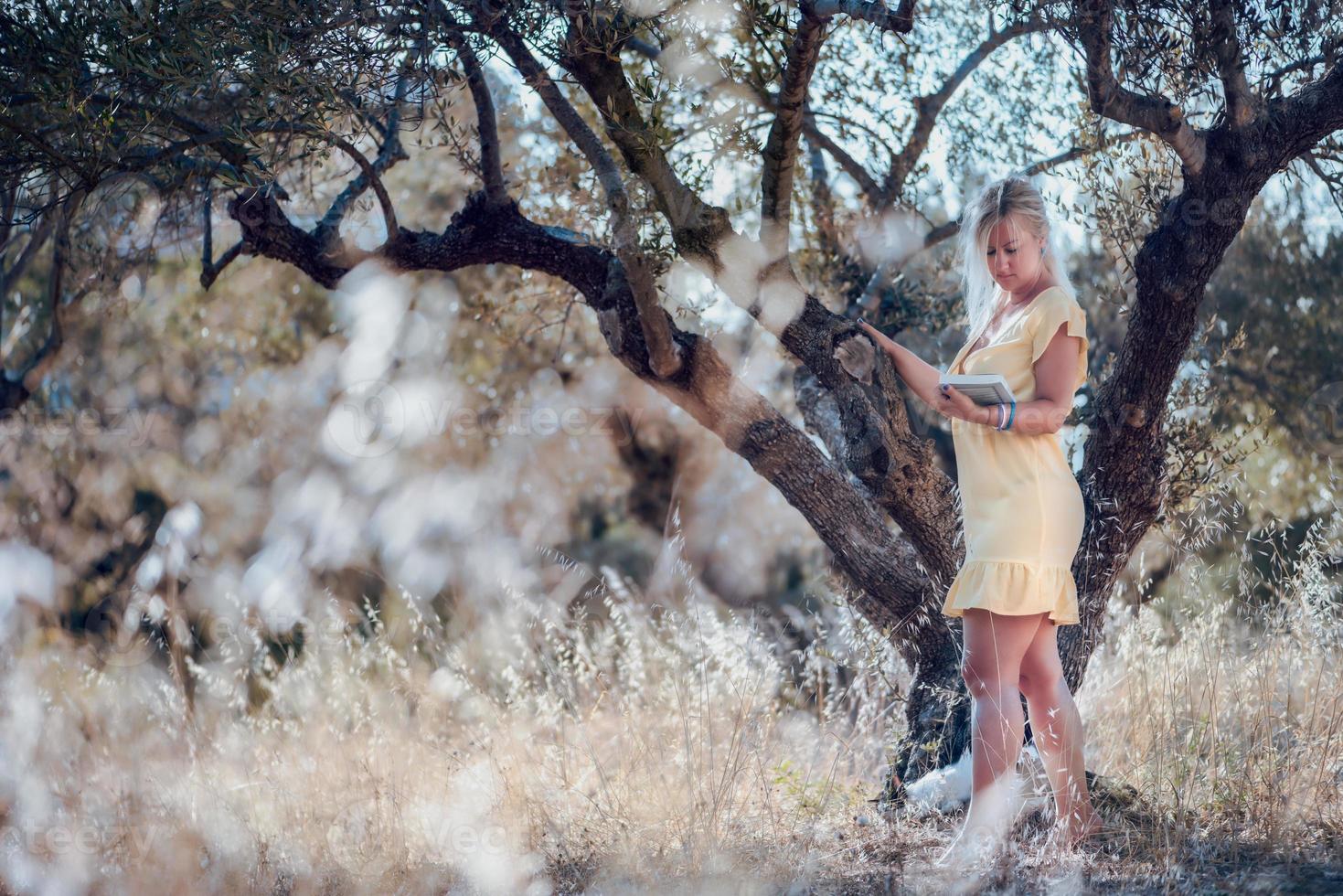 una mujer rubia descalza con un vestido amarillo de verano foto