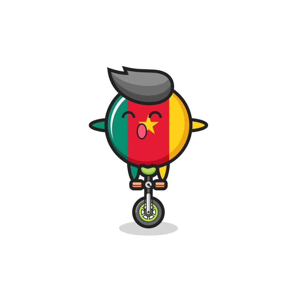 The cute cameroon flag badge character is riding a circus bike vector