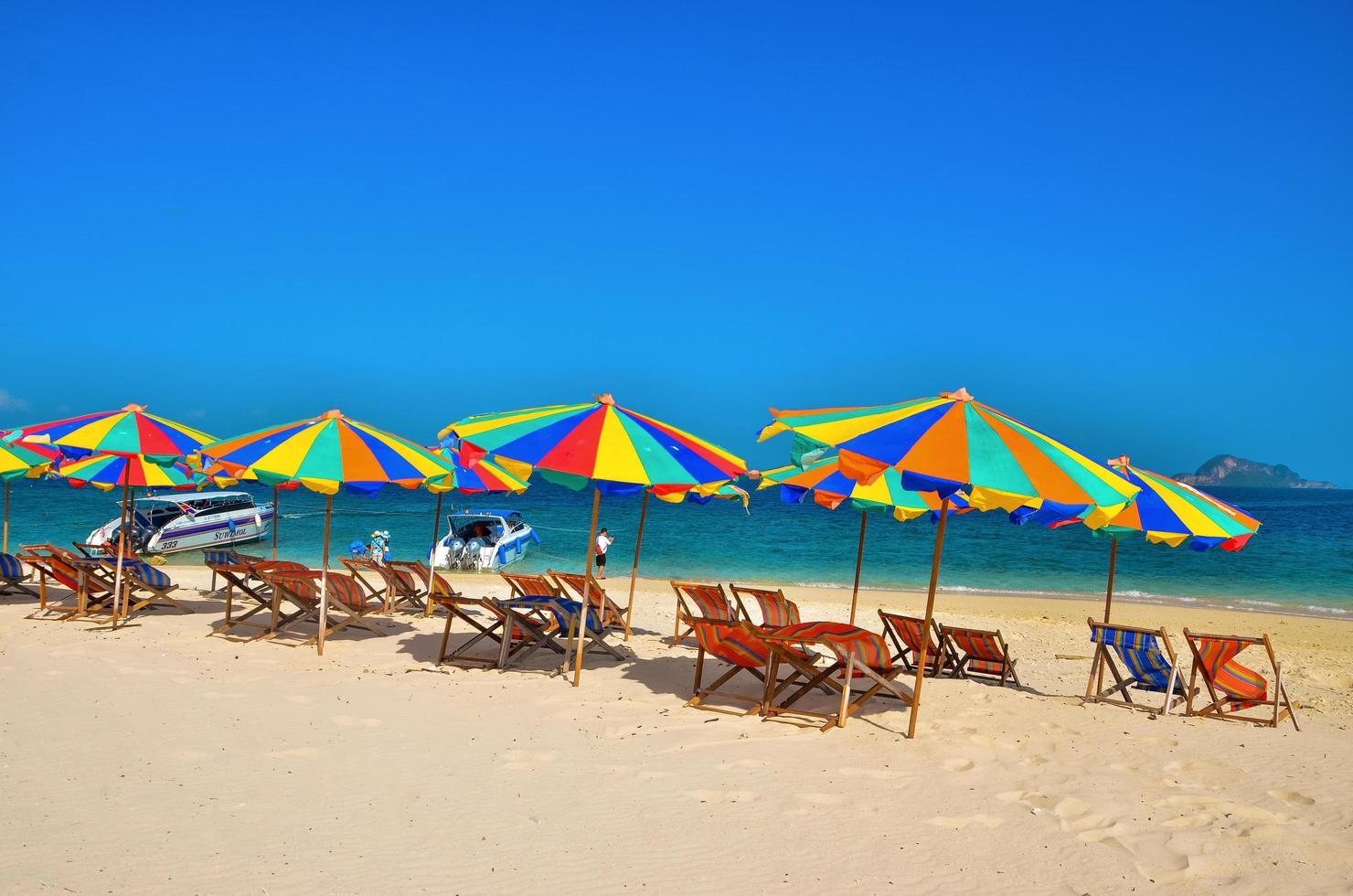 Phuket, Thailand, 2020 - Chairs and colorful umbrellas on a beach photo