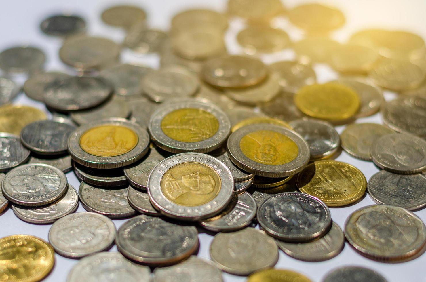 Moneda de dinero en aumento de monedas de baht tailandés de plata y oro gráficos con reflexión aislado sobre fondo blanco pilas de monedas sobre un fondo blanco. foto