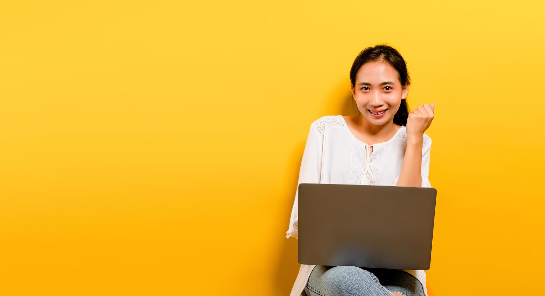 Asian woman working on his laptop computer and a happy photo