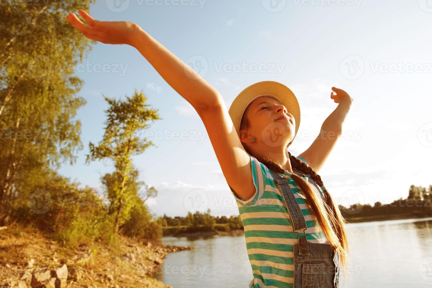 Happy little girl in a hat with open arms photo