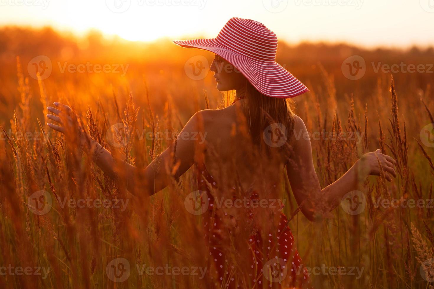 mujer feliz en un sombrero de la hierba del prado foto