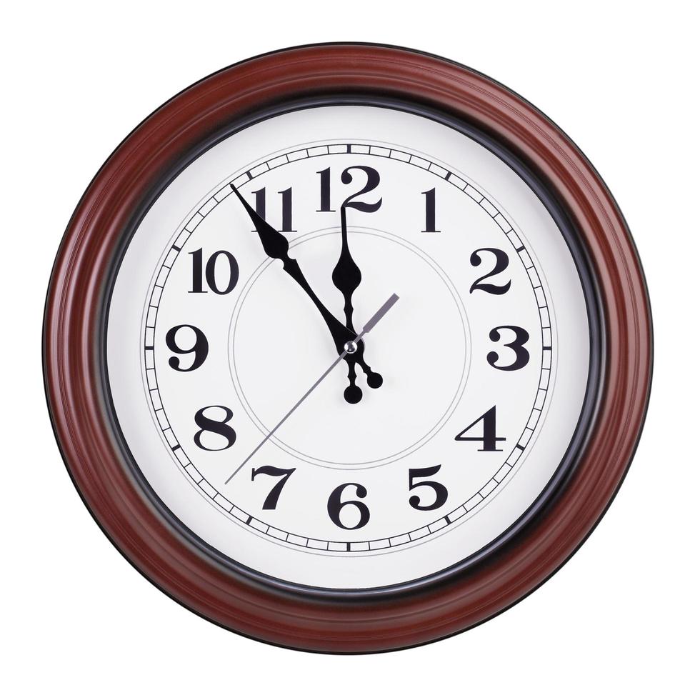 Round clock shows five minutes to twelve photo