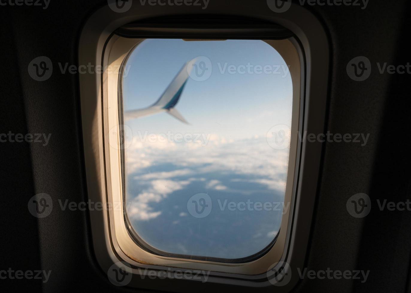 Vista panorámica de la luz del sol a través de la ventana del avión en el cielo foto