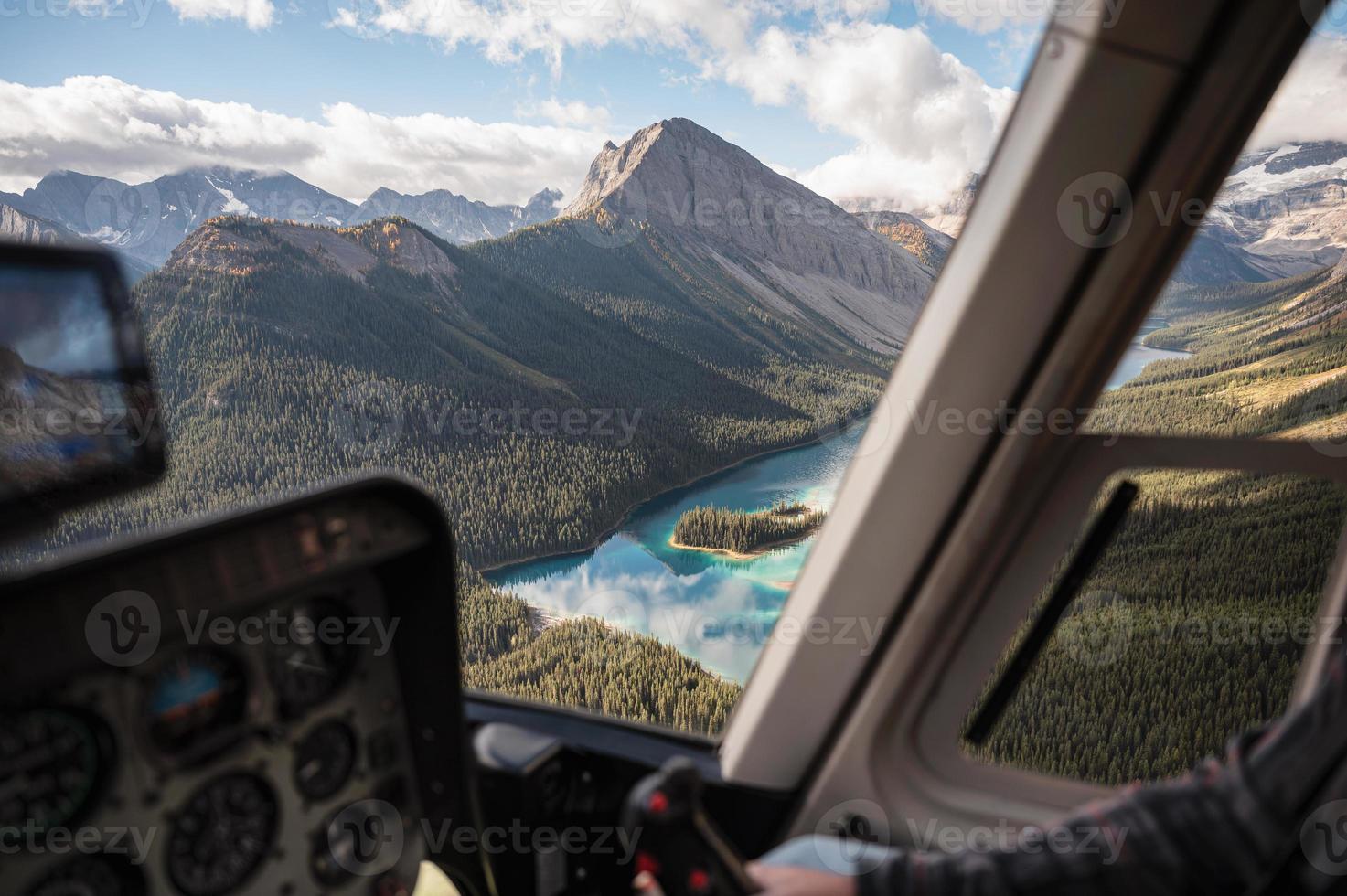 Inside of helicopter flying on rocky mountains with colorful lake photo