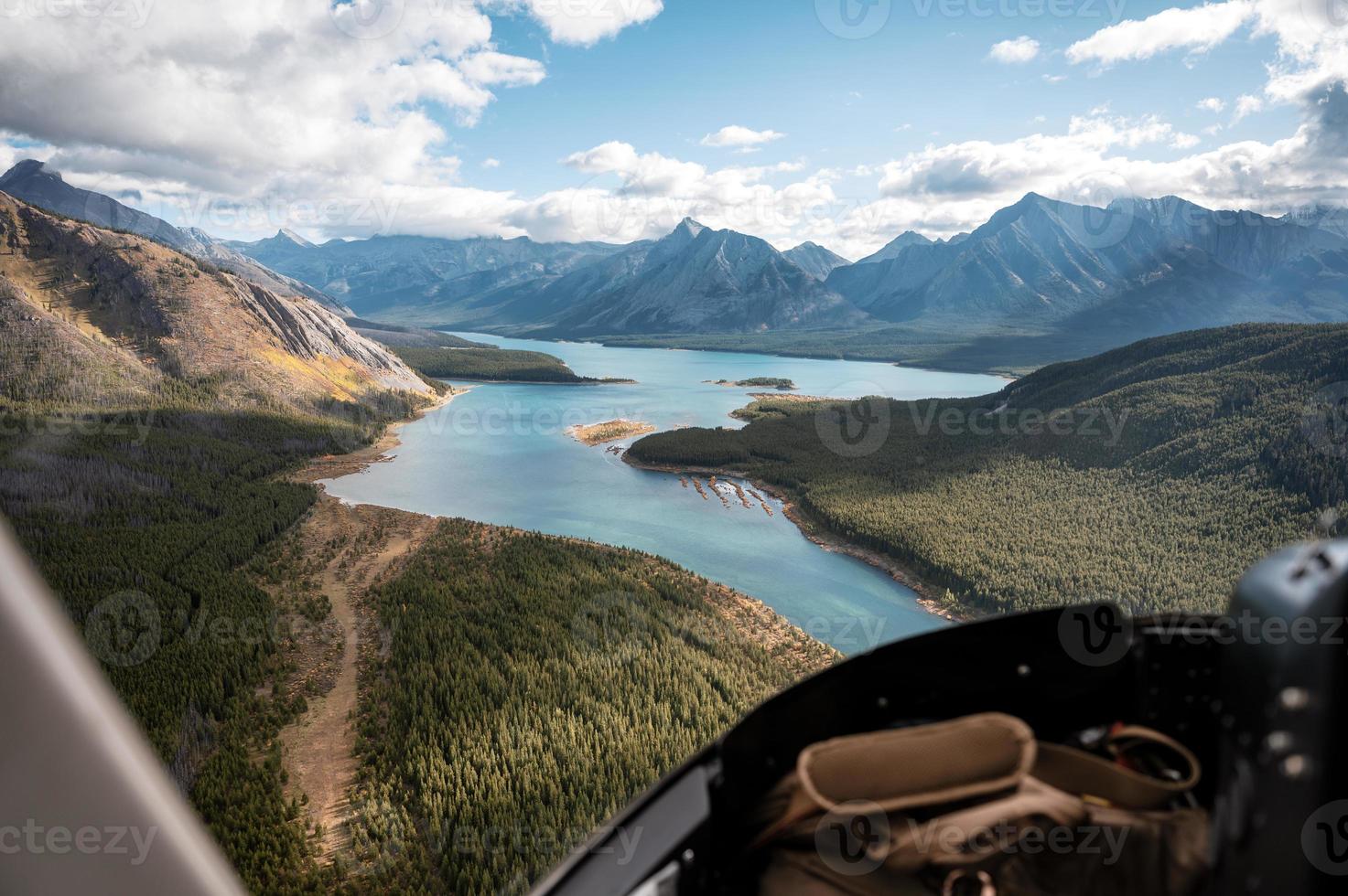 Dentro del helicóptero que volaba sobre montañas rocosas con un lago colorido foto