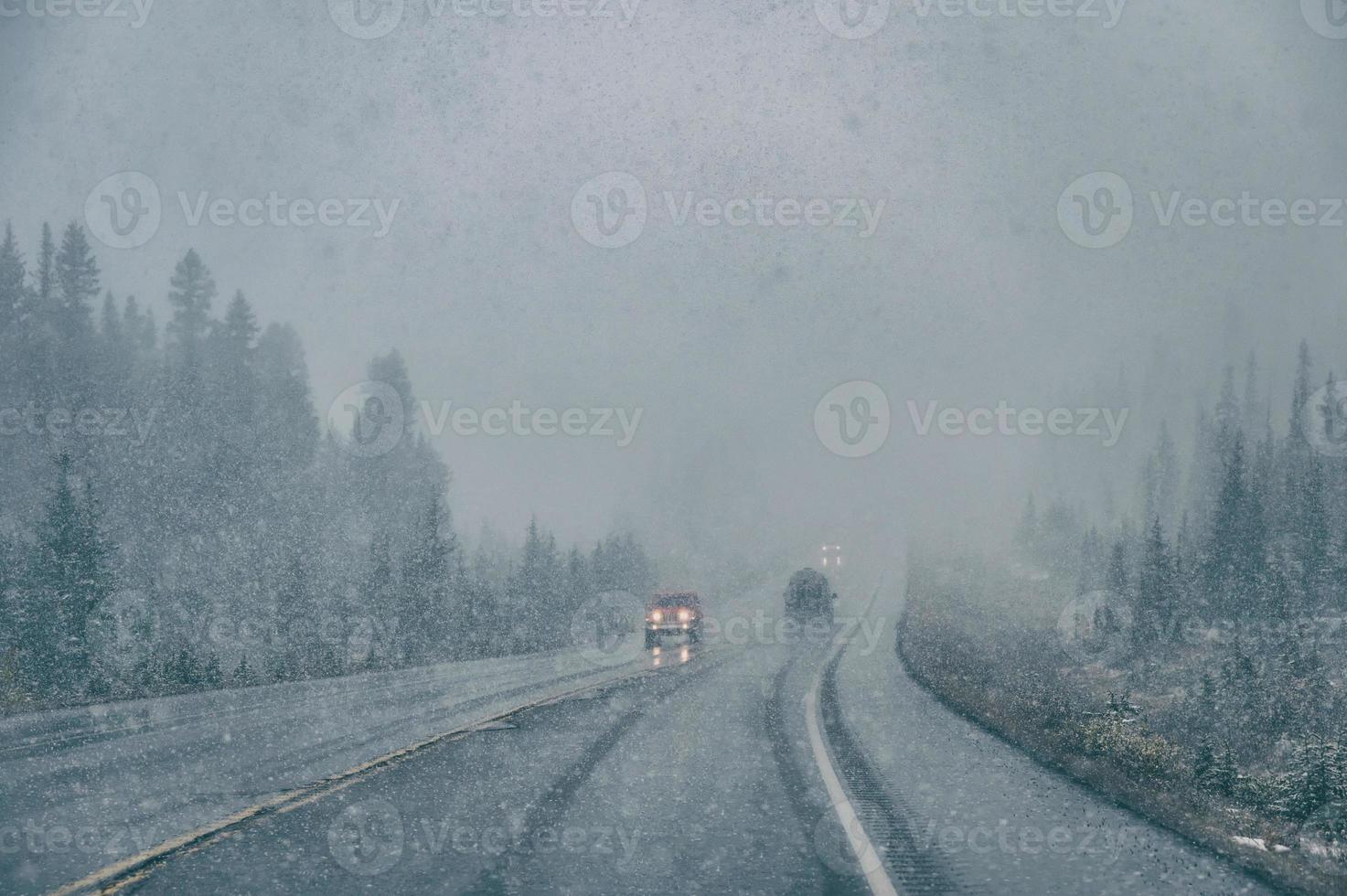 Car driving with poor visibility in blizzard with heavy snowing photo