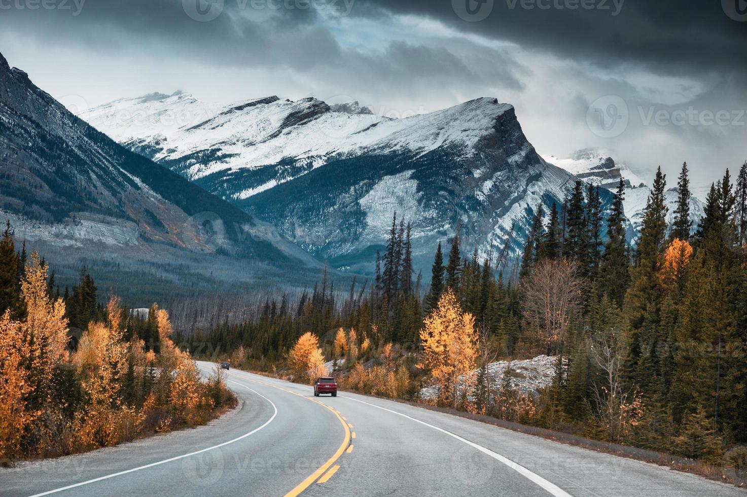 viaje por carretera con montañas rocosas en el bosque otoñal en el parque nacional banff foto