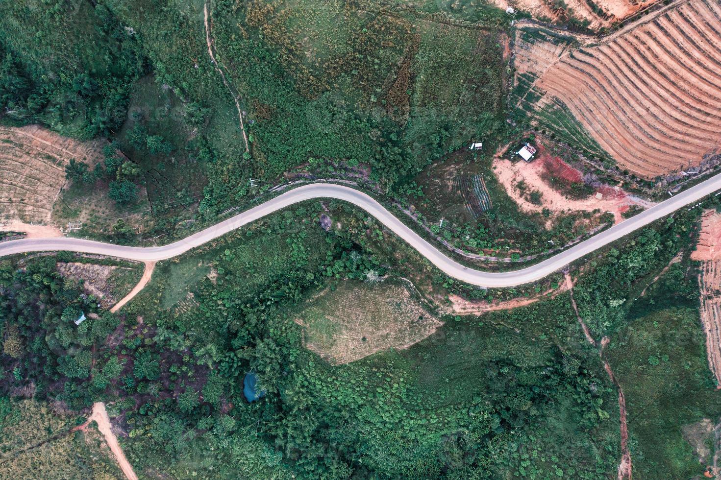 Top view of curved asphalt road on hill in the forest photo