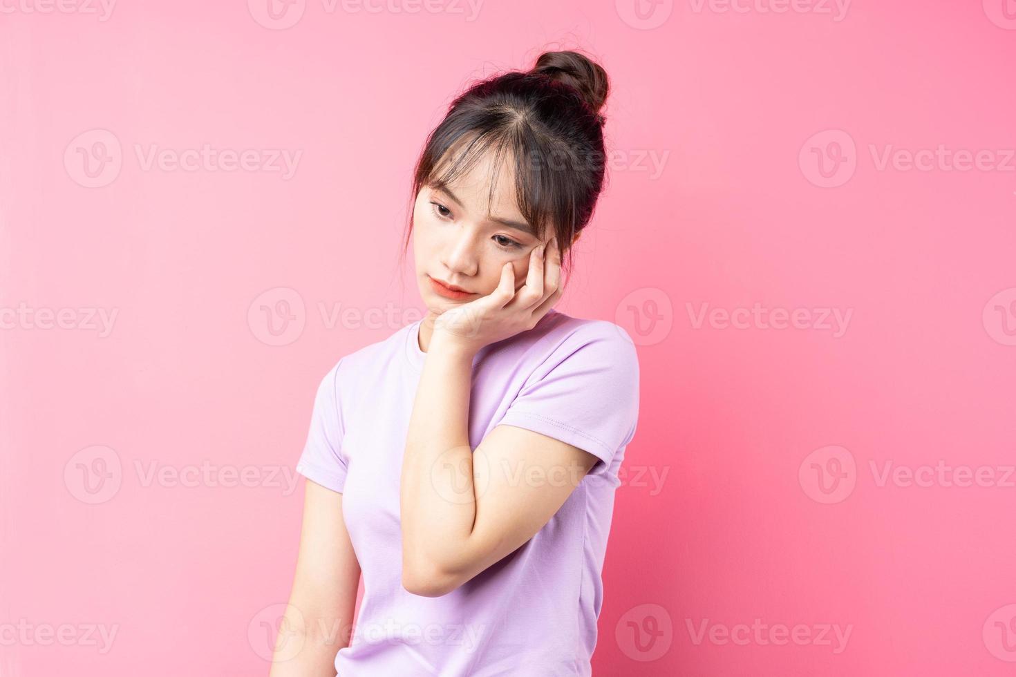 Retrato de niña deprimida, aislado sobre fondo de color rosa foto