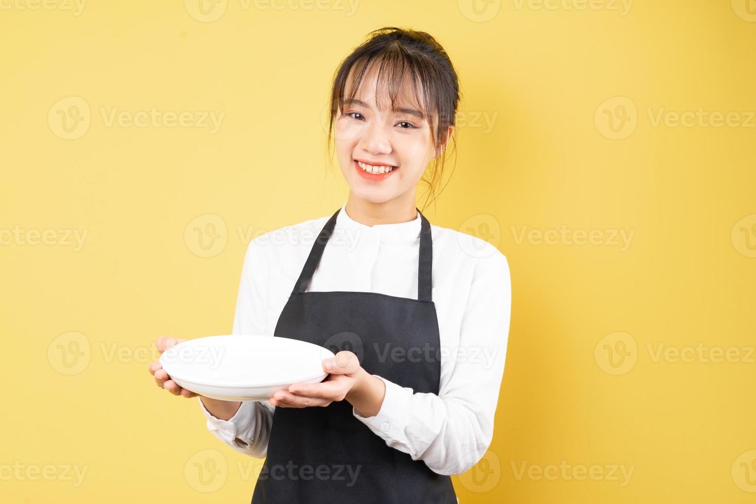 Retrato de camarera alegre sobre fondo amarillo foto