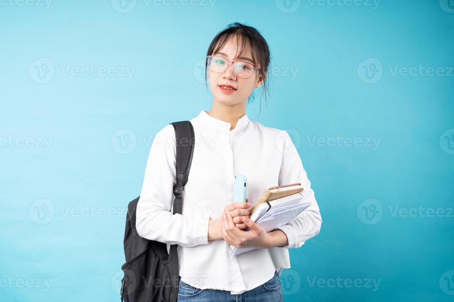 Portrait of a beautiful schoolgirl on a blue background photo