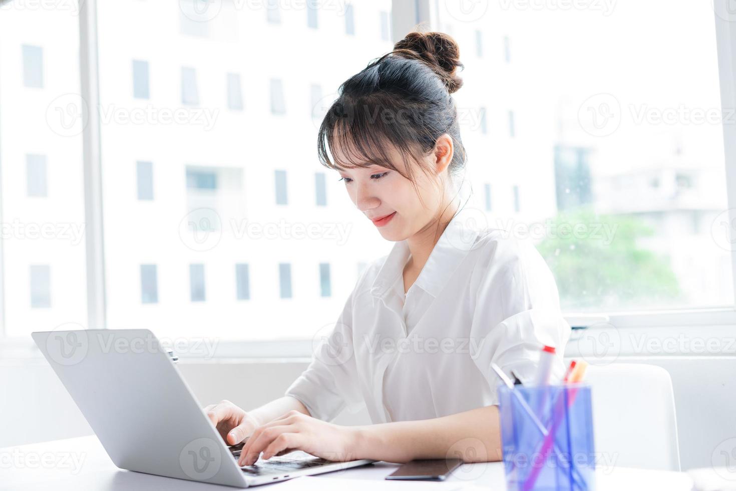 Portrait of happy and working young businesswoman photo