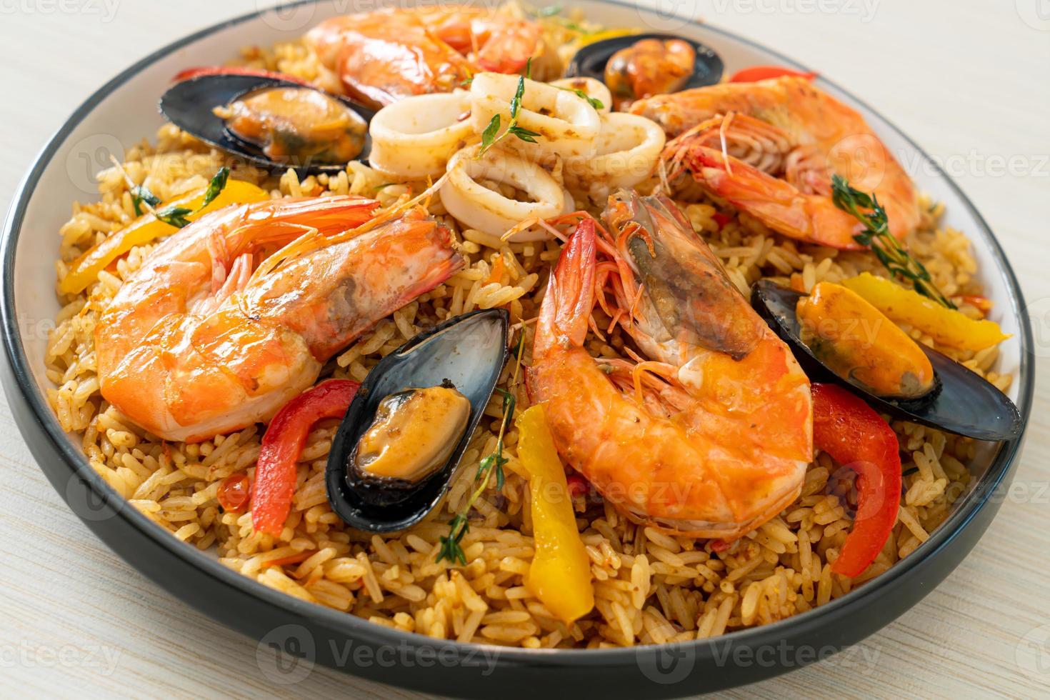 paella de marisco con gambas, almejas, mejillones sobre arroz con azafrán foto