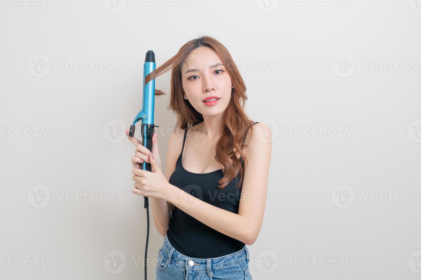 portrait beautiful Asian woman using hair curler or curling iron photo