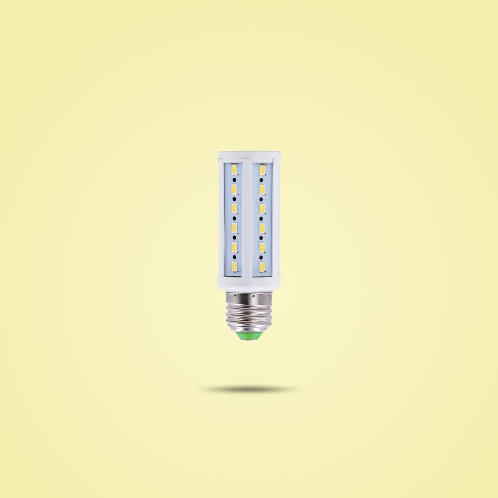 LED energy saving lamp 230v isolated on yellow pastel color background. photo