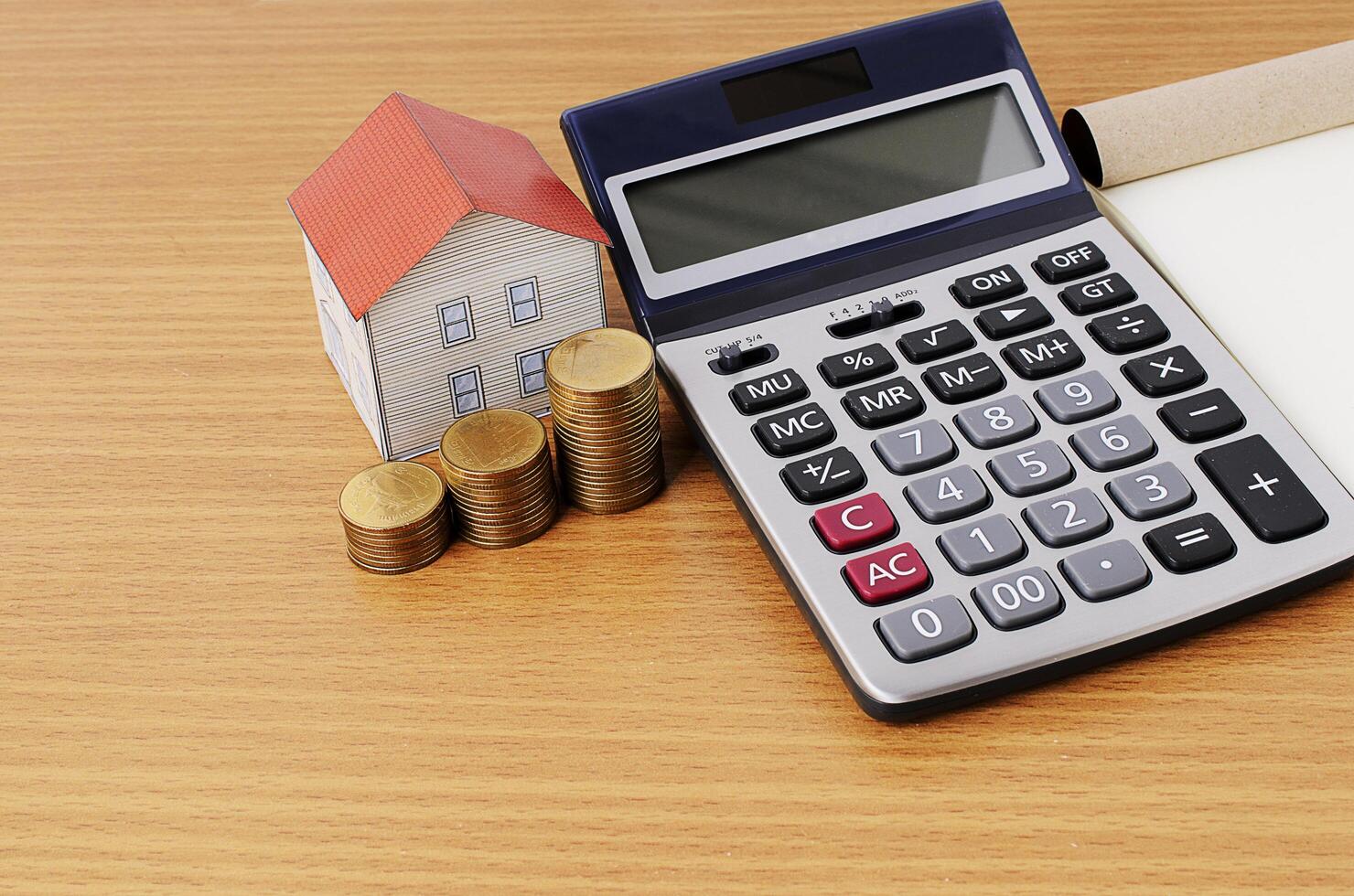 Mortgage loans concept with calculator and coins stack and paper house photo