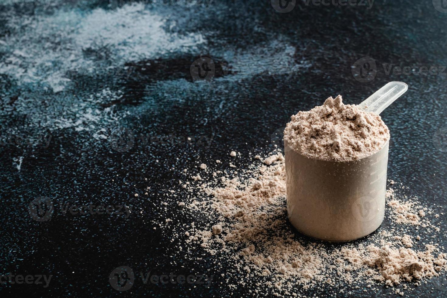 Top view whey protein scoop on dark background, copy space photo