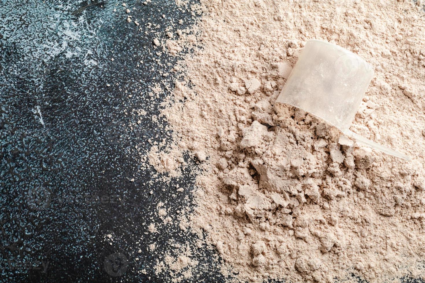 Top view whey protein scoop on dark background, copy space photo