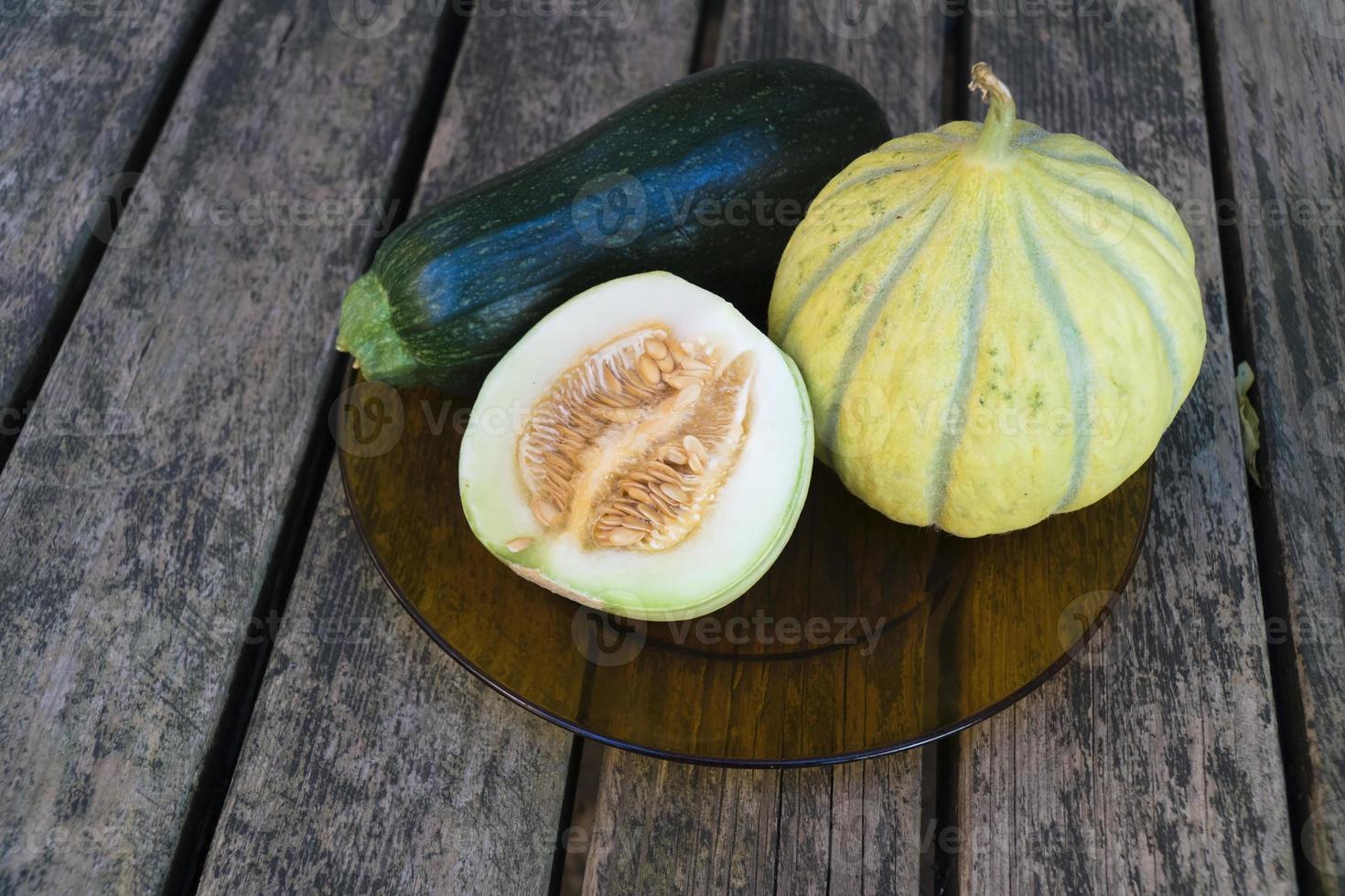 Gmo free melons and zucchini on a wooden table photo