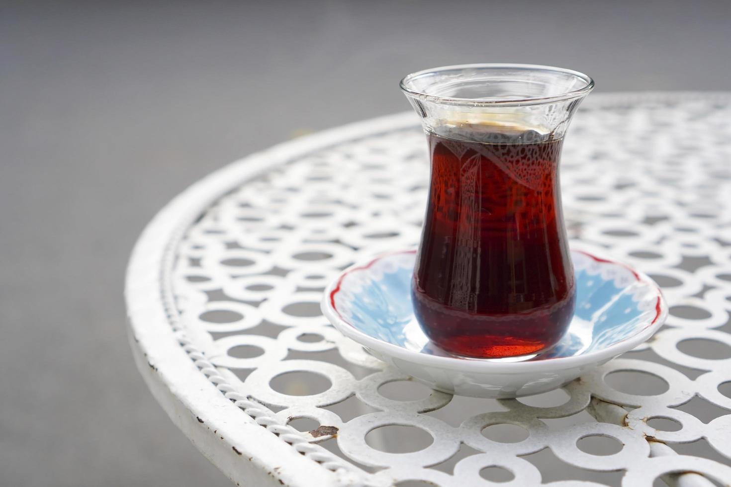 Served tea on a turkish tea glass on a metal cafe table at street photo