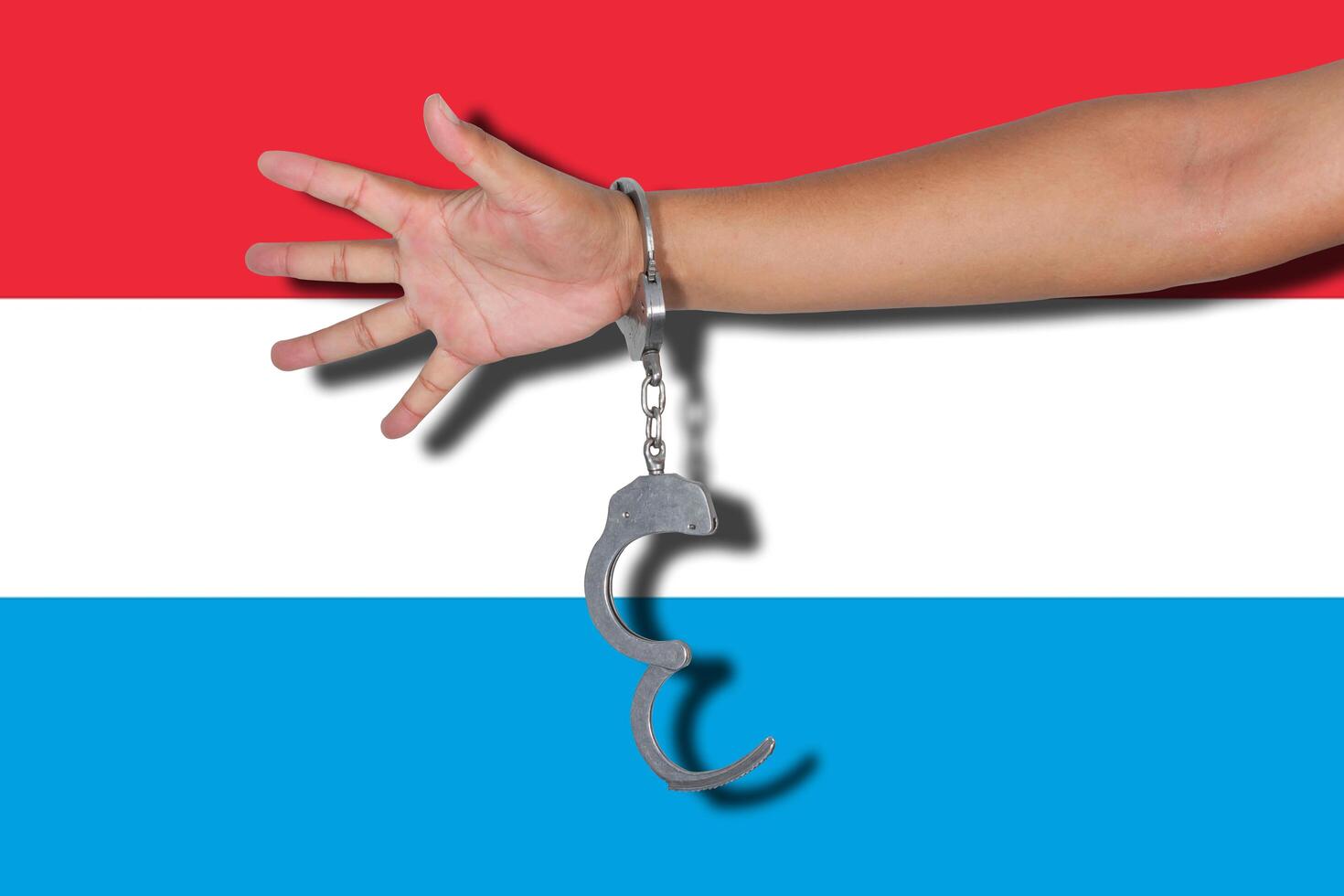 handcuffs with hand on Luxembourg flag photo