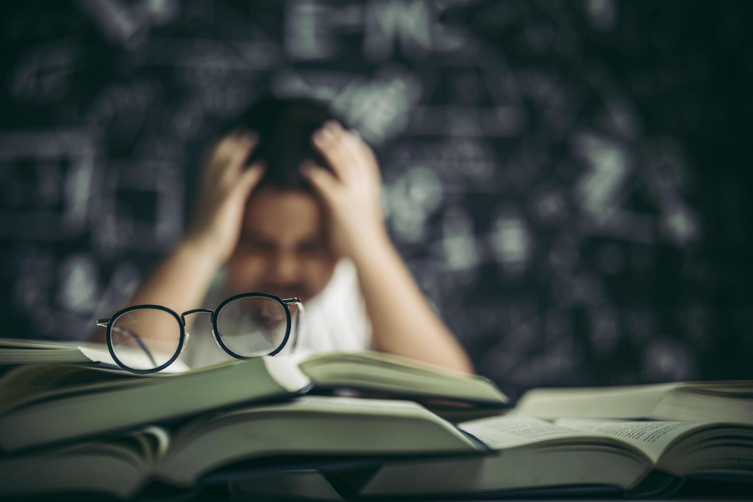 Boys with glasses write books and think in the classroom photo
