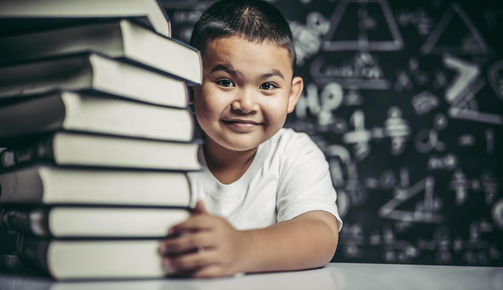 un niño abrazando una pila de libros. foto