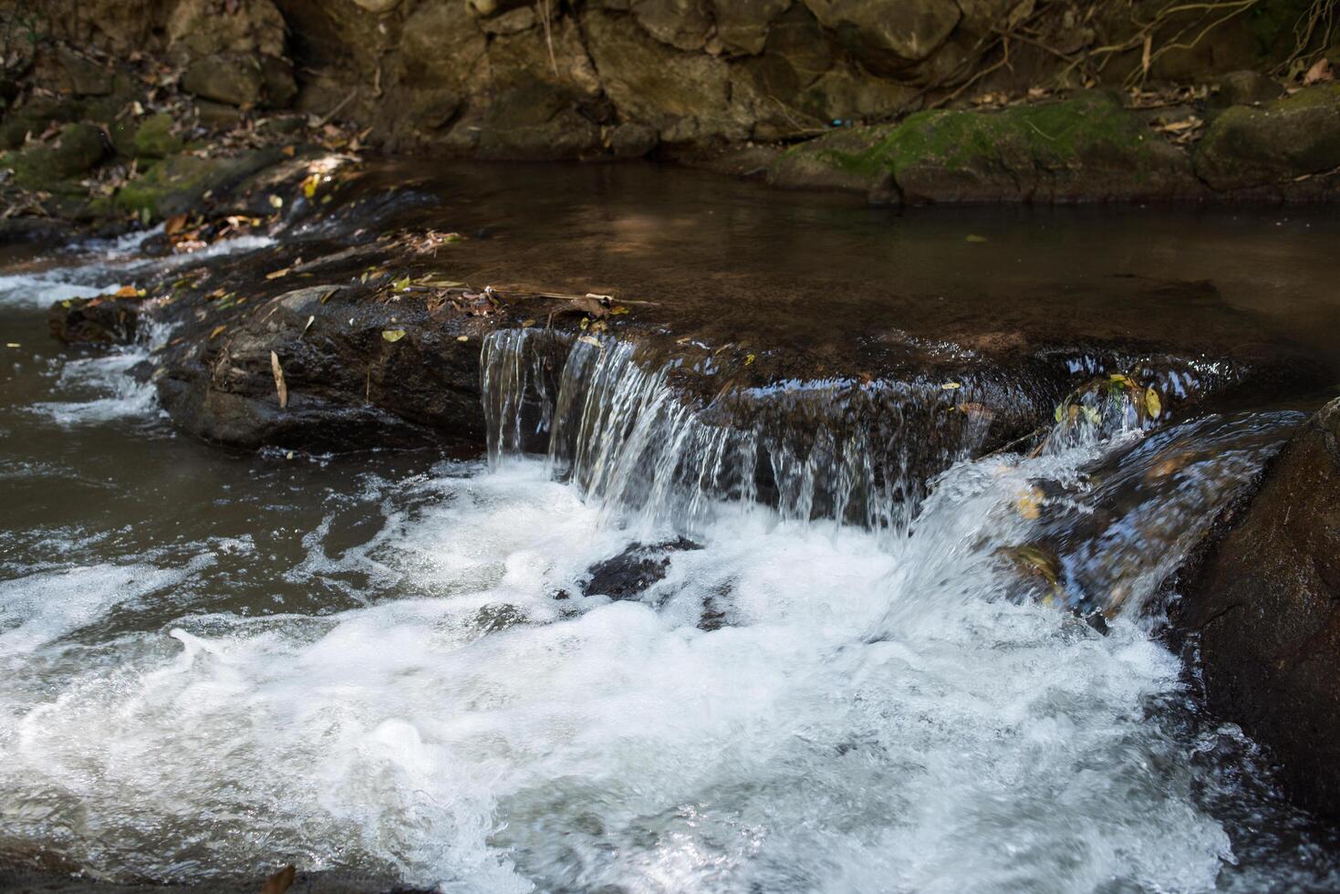 Cascada en la naturaleza y fondo de piedra. foto