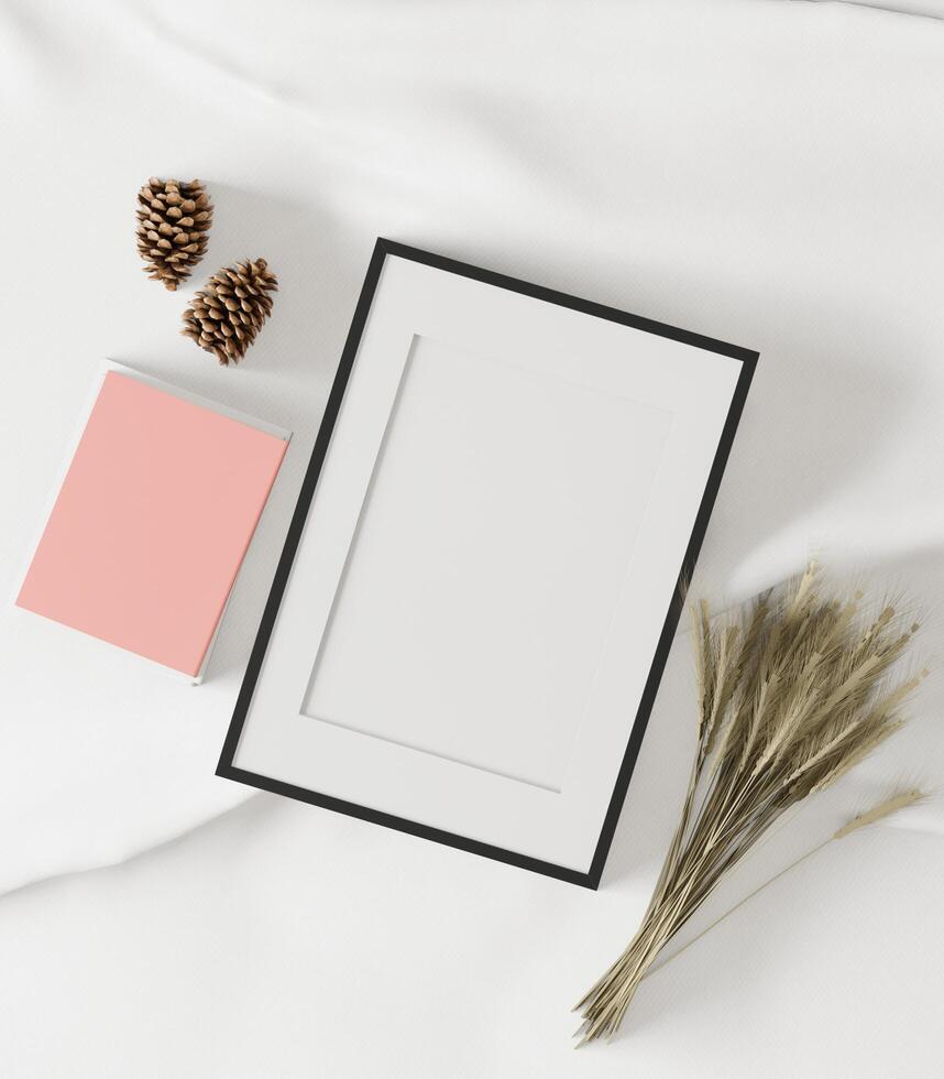 The picture frame was placed on a white cloth covered with dry grass and pine cones. photo