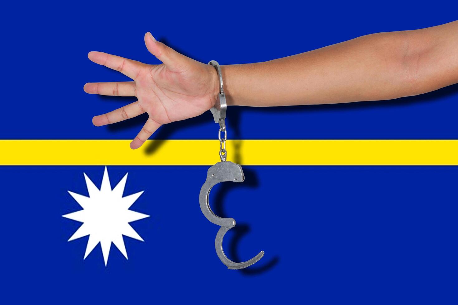 handcuffs with hand on Nauru flag photo