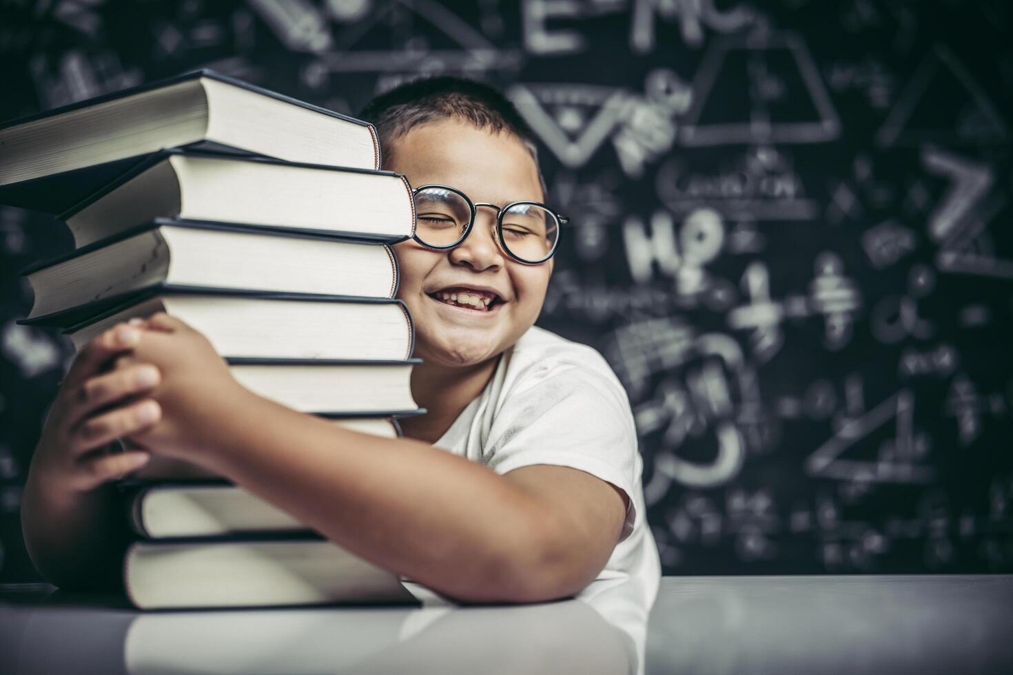 A boy hugging a pile of books. photo