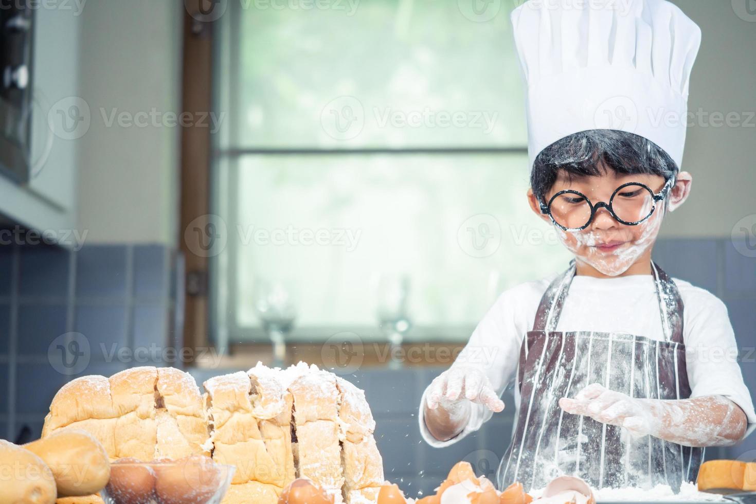 Asian Boy wear glasses Tease dad cooking with white flour Kneading bread dough teaches children practice baking ingredients bread, egg on tableware in kitchen lifestyle happy Learning life with family photo