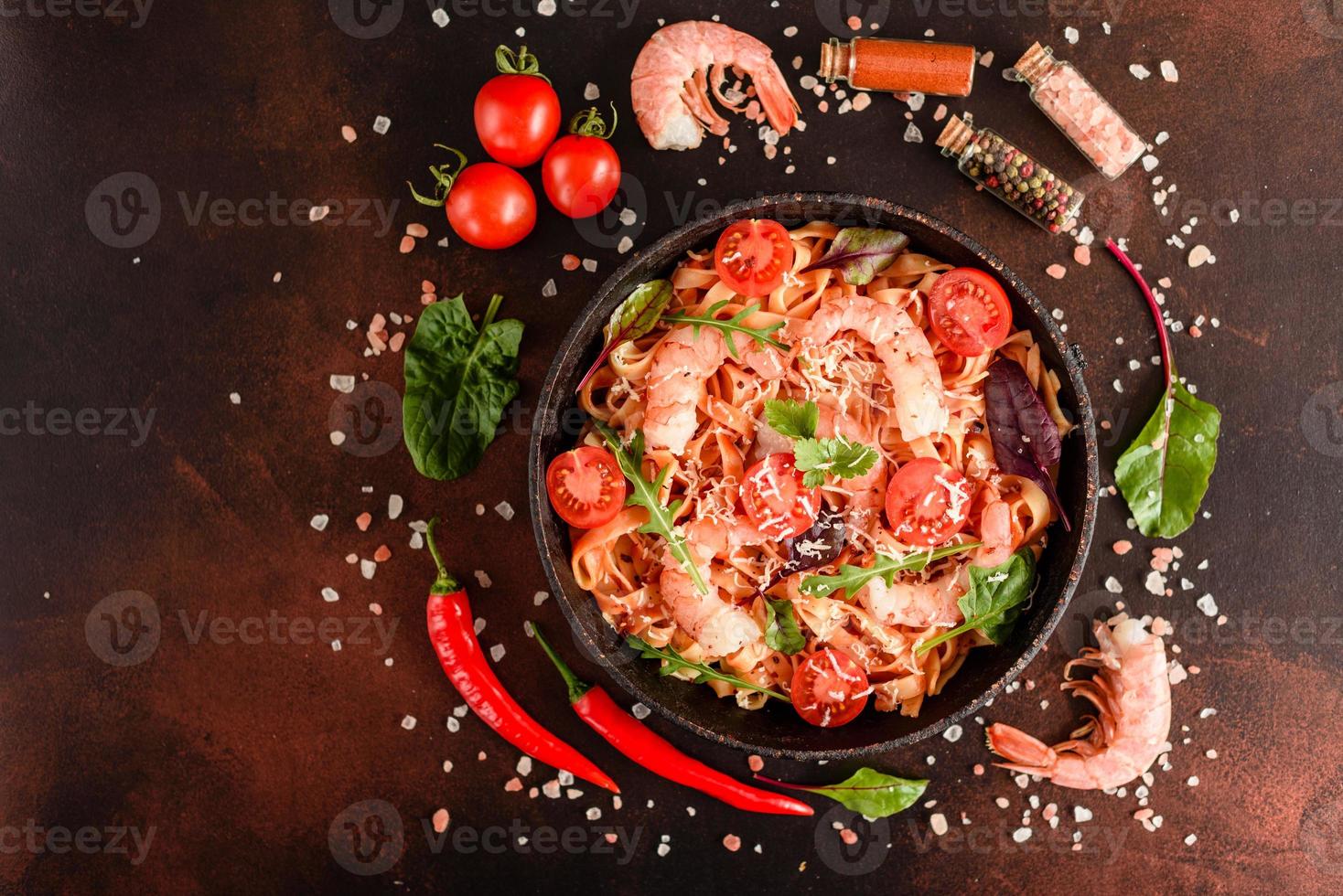 Sabrosa pasta con camarones y tomate en una sartén foto