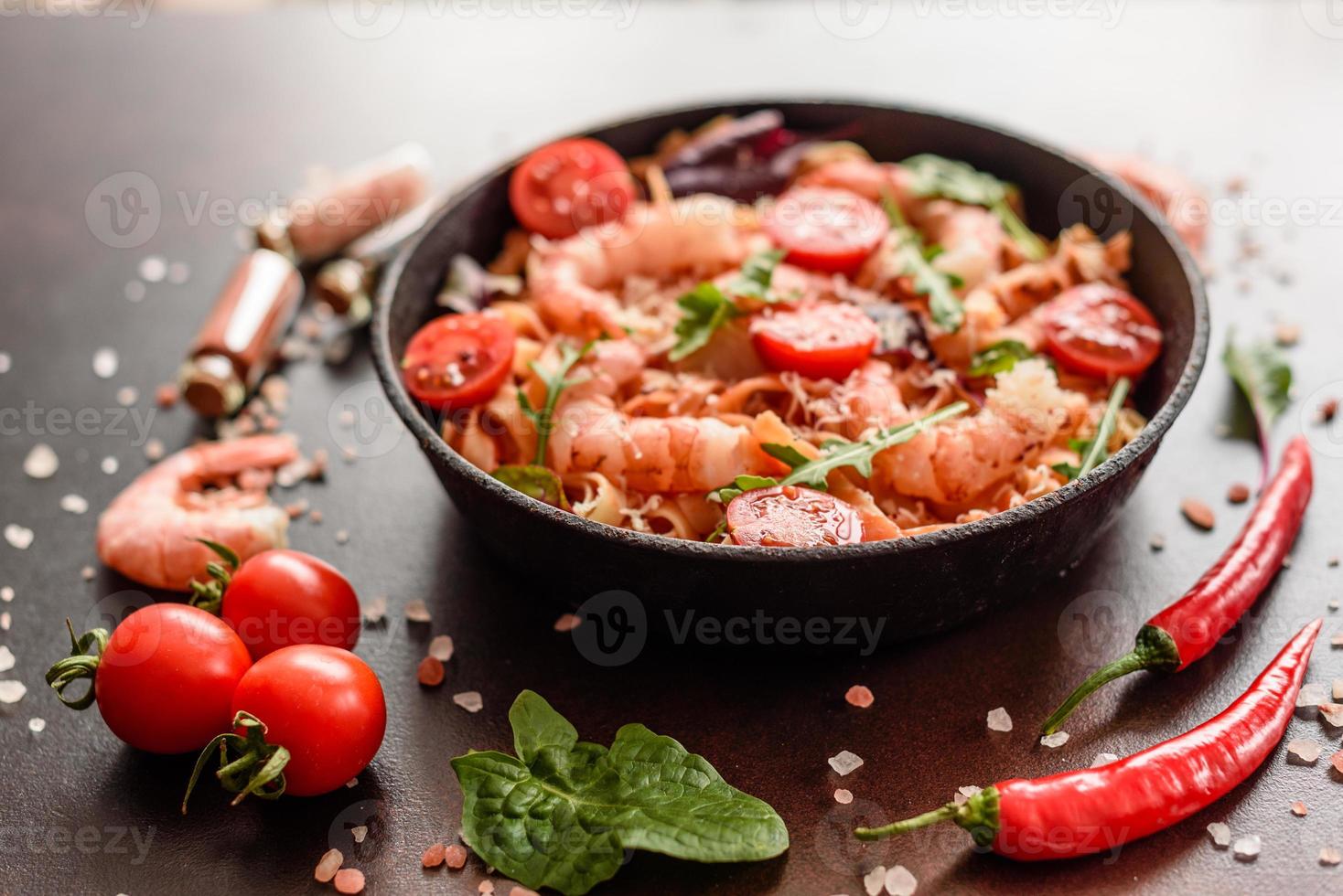 Tasty pasta with shrimp and tomato on a frying pan photo