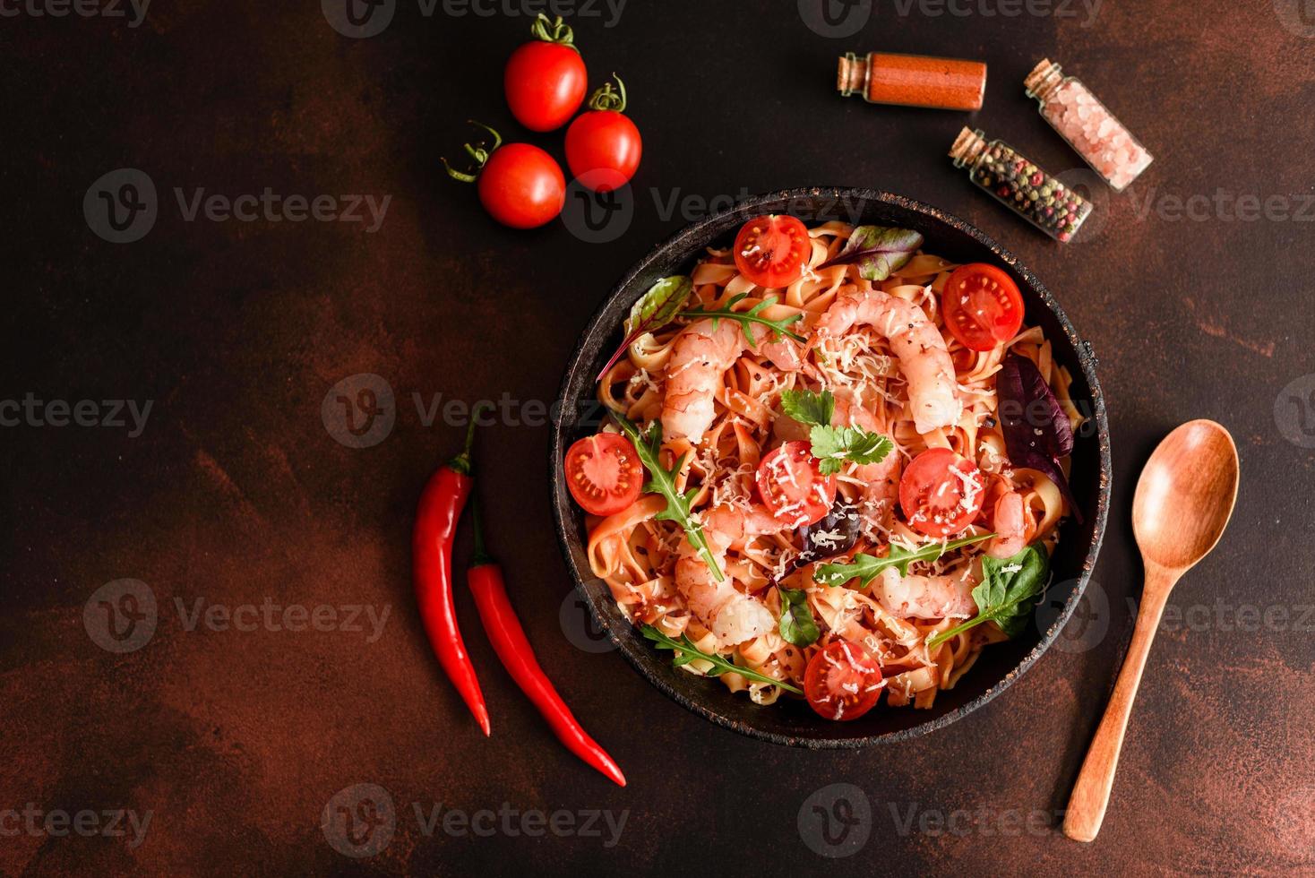 Tasty pasta with shrimp and tomato on a frying pan photo