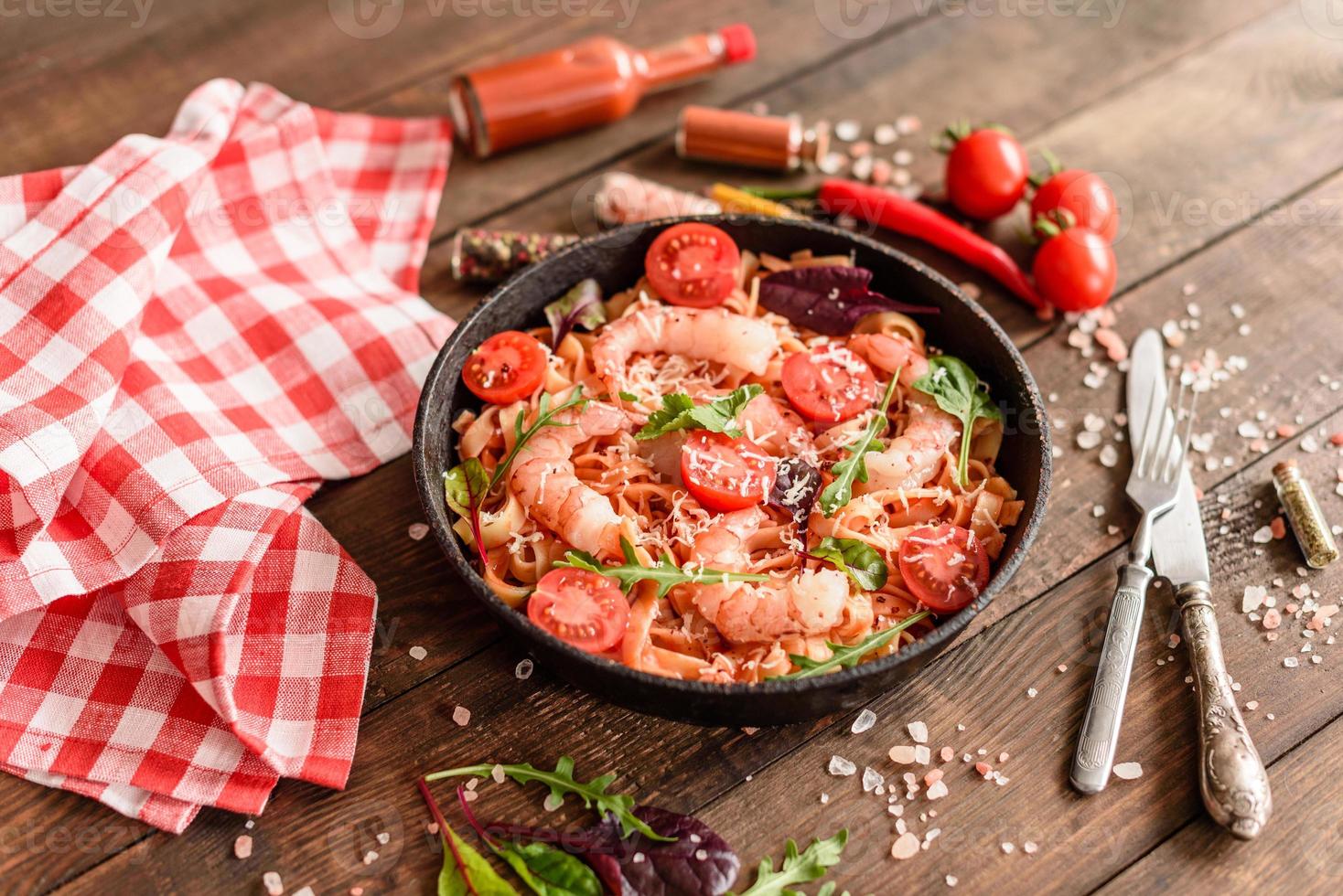 Tasty pasta with shrimp and tomato on a frying pan photo