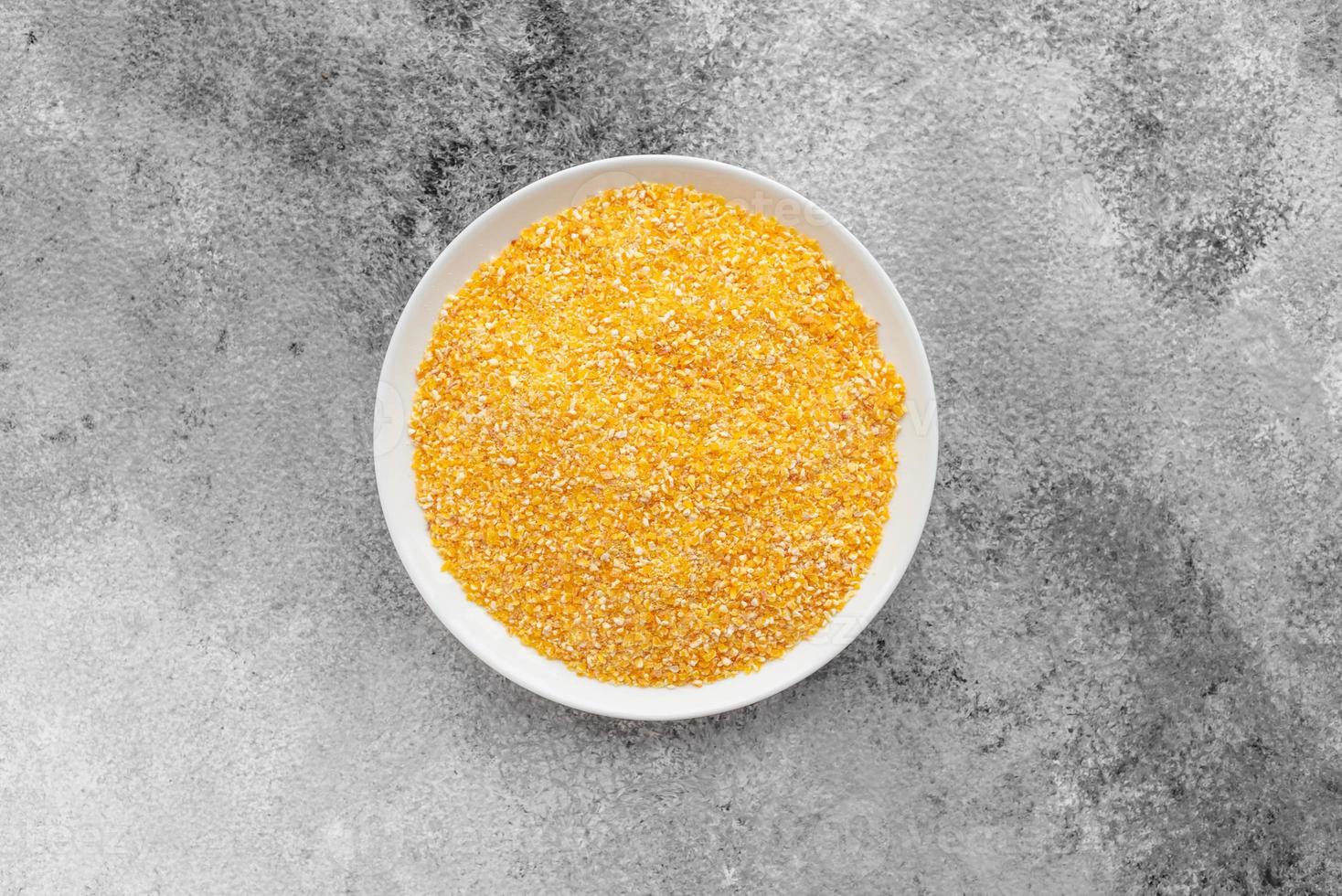 Cornmeal mush in a white saucer on a gray concrete background photo