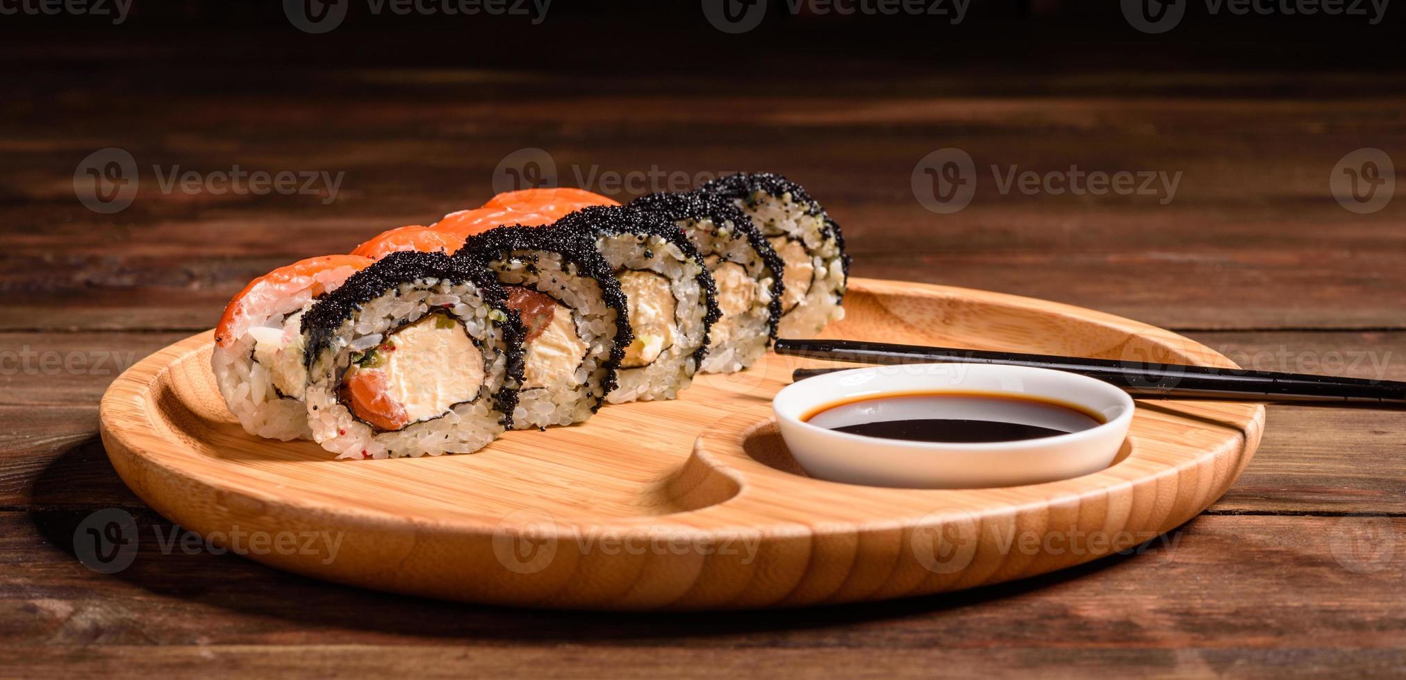 varios tipos de sushi servido sobre un fondo oscuro foto