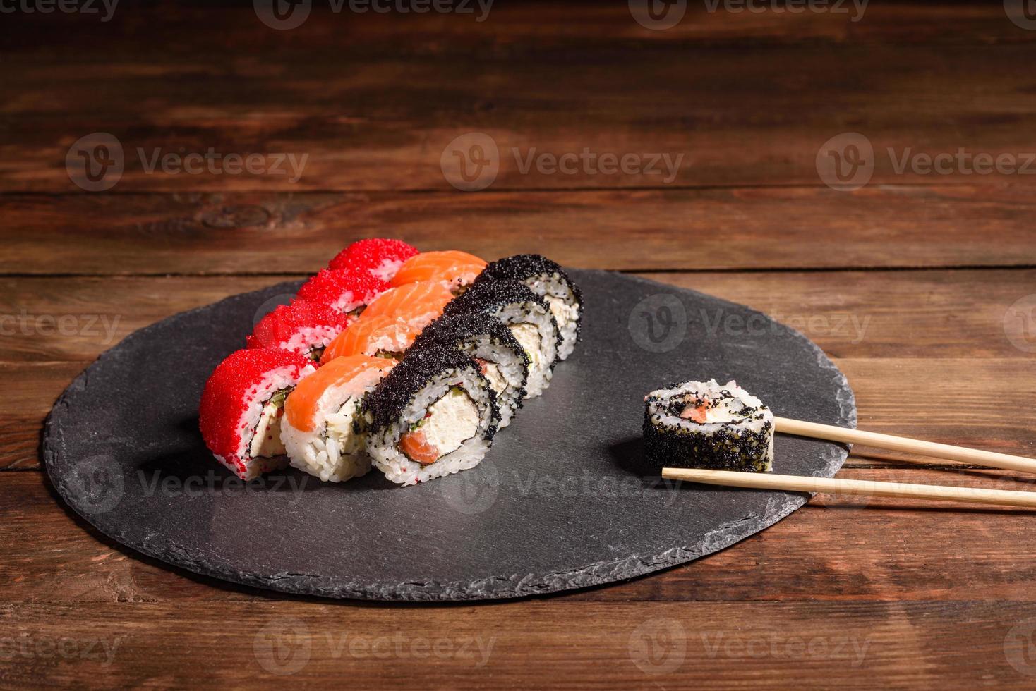 varios tipos de sushi servido sobre un fondo oscuro foto