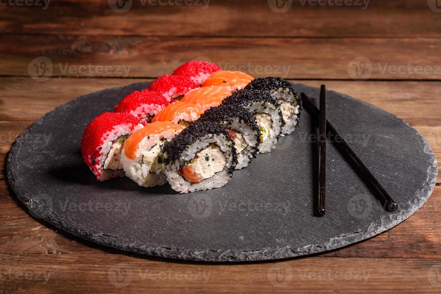 varios tipos de sushi servido sobre un fondo oscuro foto