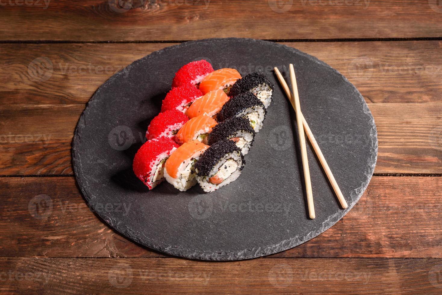 varios tipos de sushi servido sobre un fondo oscuro foto