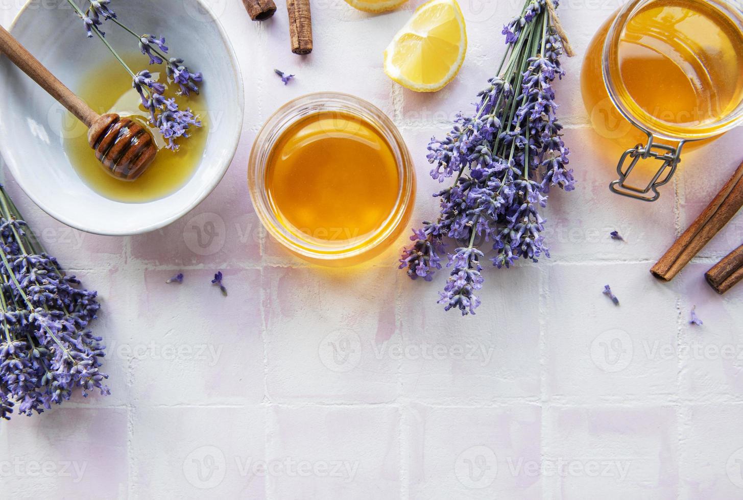 Jars and bowl with honey and fresh lavender flowers photo